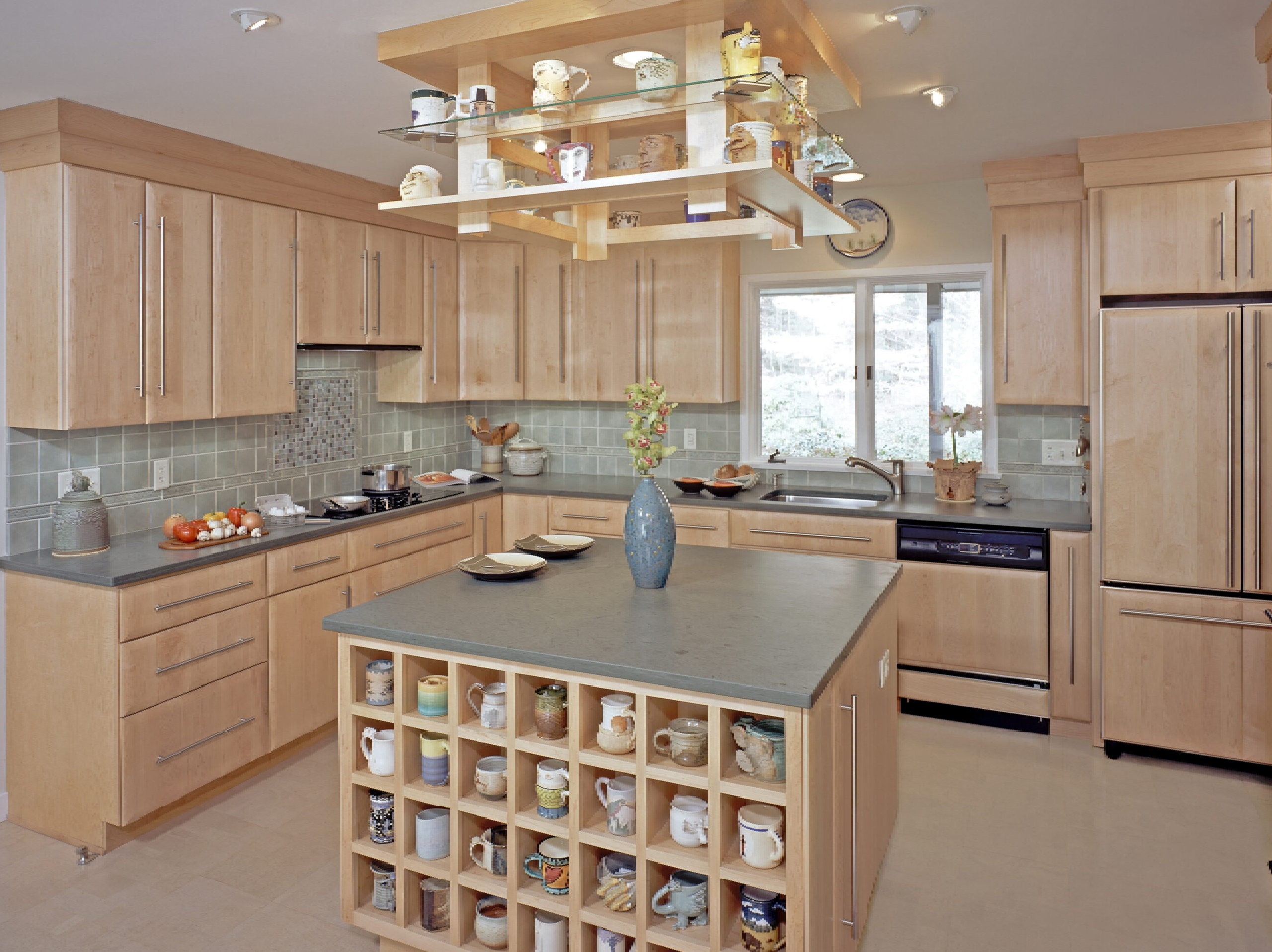 A spacious kitchen with wooden cabinets, a central island with a built-in wine rack, stainless steel appliances, and green tile backsplash. natural light illuminates the room.